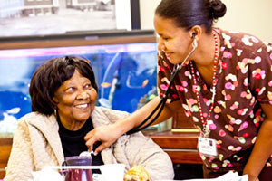 A Riverside PACE nursing assistant listens to the heartbeat of a PACE participant at the Center in Hampton